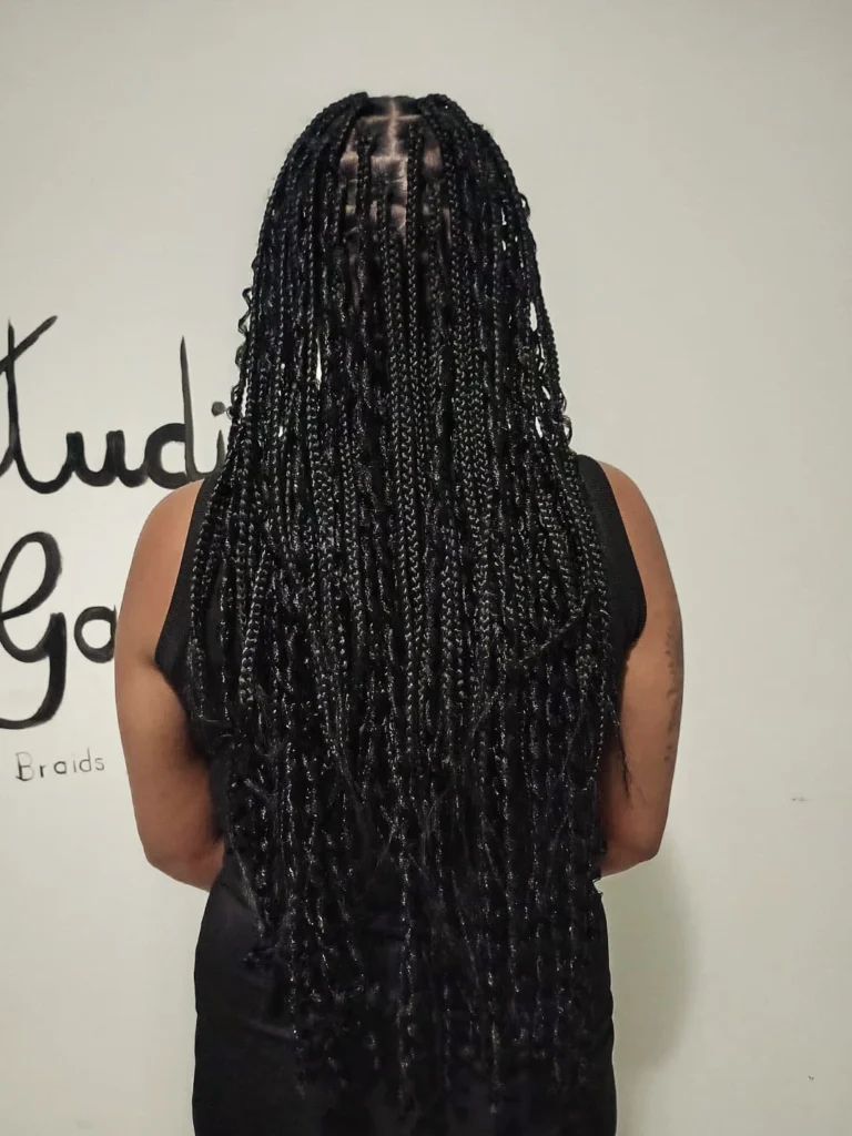 Extra long black goddess braids with loose wavy strands and slim braid sections.