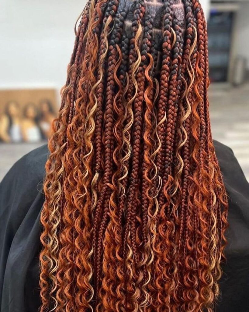 Reddish brown goddess braids with caramel blonde curly highlight strands woven throughout.