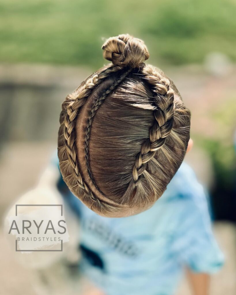 Curved Dutch braids on brunette hair styled into a small top knot.
