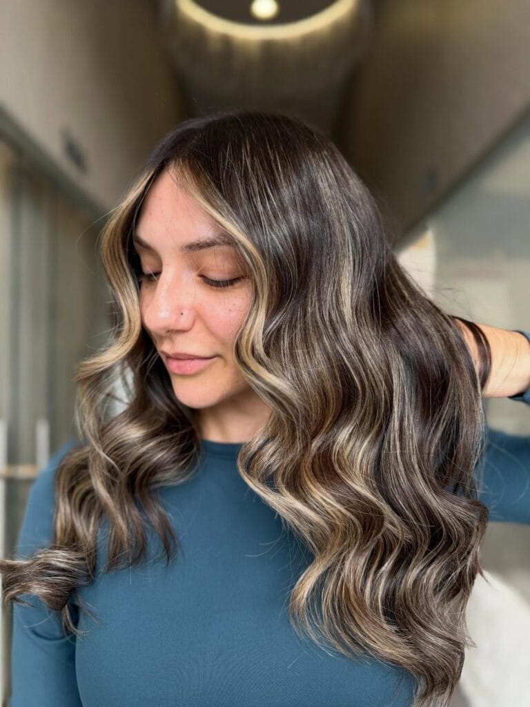 Long wavy brunette hair with cool toned ash brown highlights.