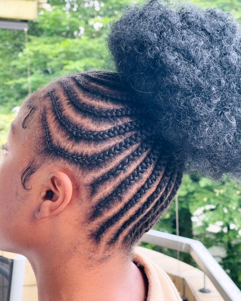 Curved cornrow braids styled upward into a high braided bun.