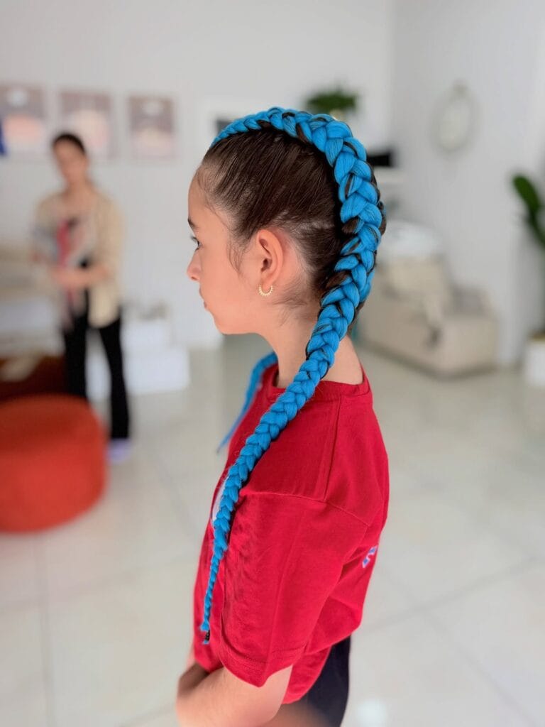 Straight back cornrows with long bright blue braided extensions.
