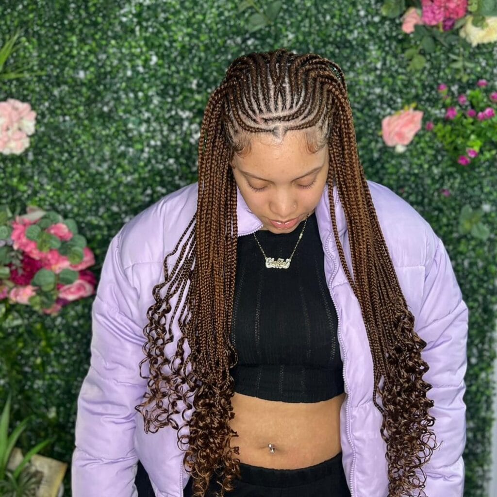 Cornrows flowing into long braids with loose curly ends.