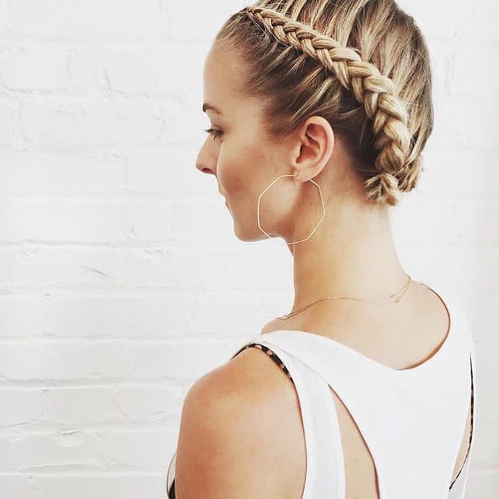 Thick crown braid wrapped around the head in a sporty style.
