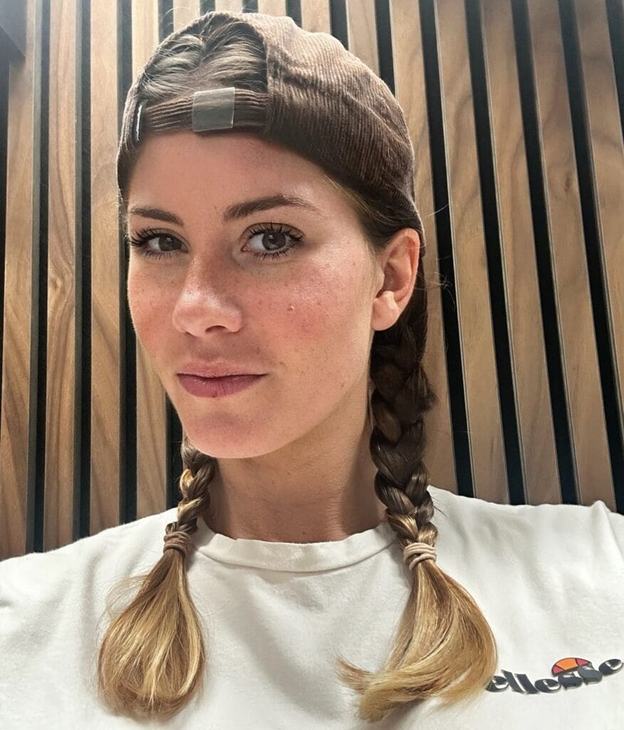 Two short braids parted at the center with soft ends.