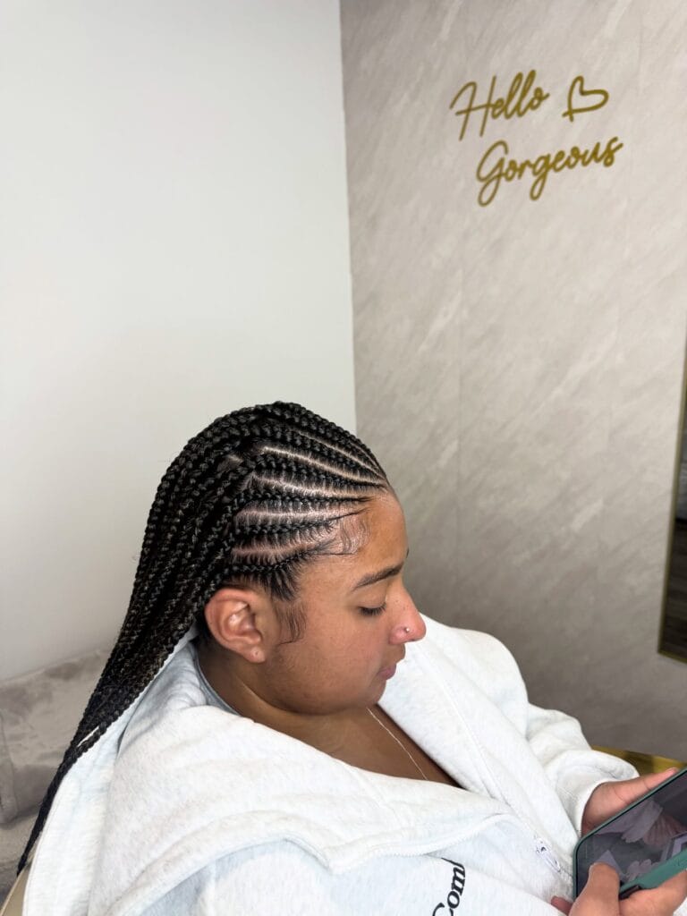 Side cornrows braided diagonally into long braids over the shoulder.