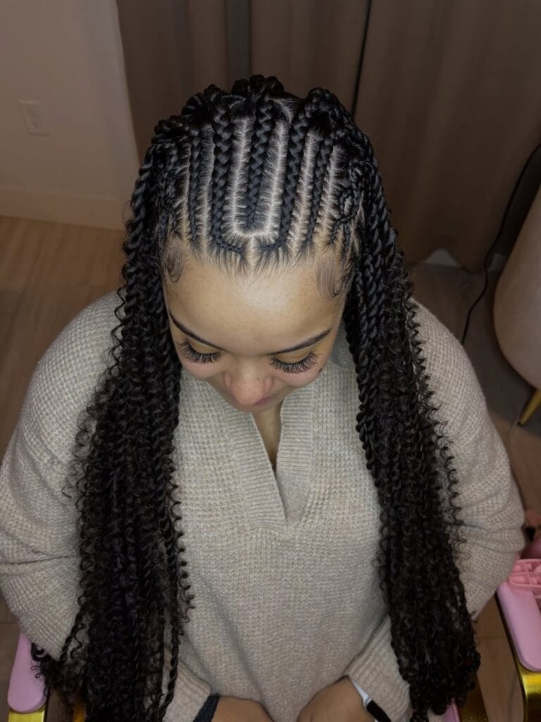 Center parted cornrows braided into thick long braids.