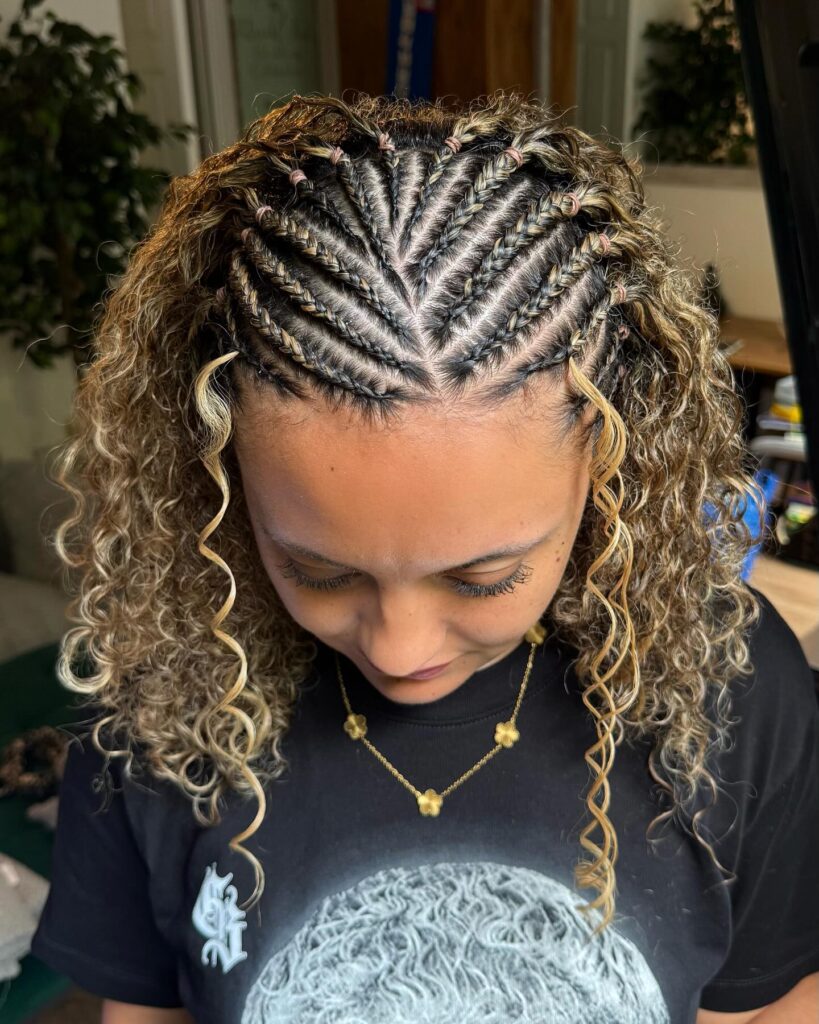 Intricate cornrow braids with blonde highlights and loose curly strands.