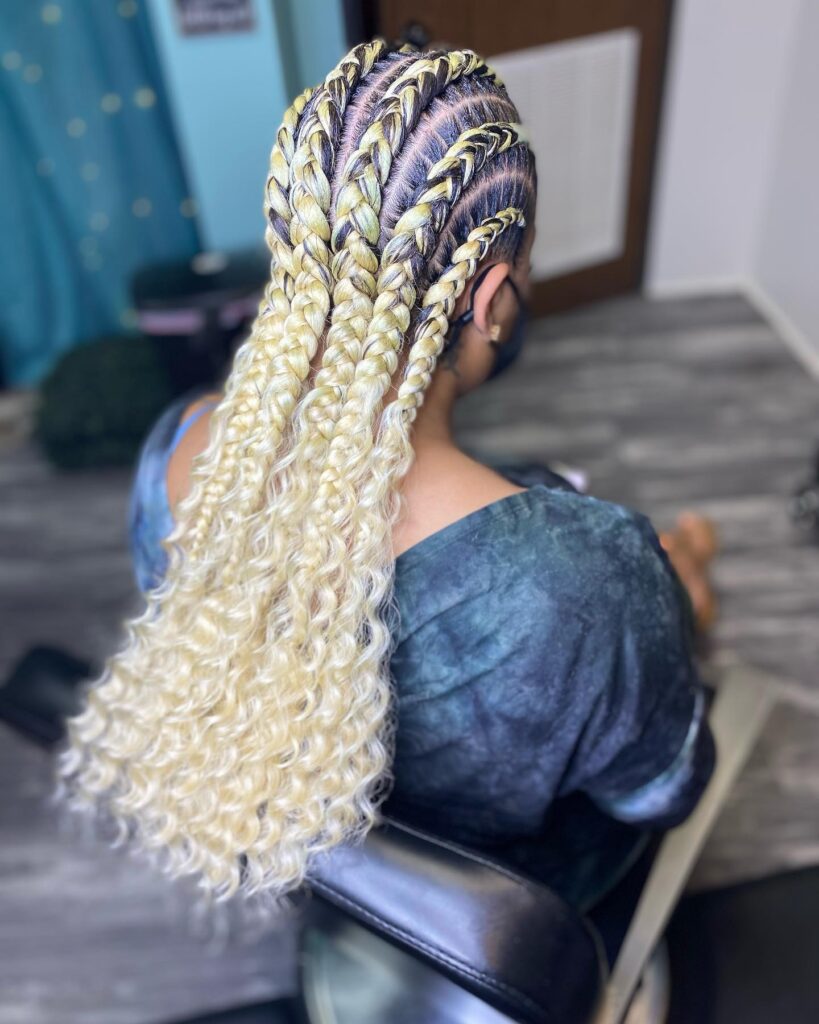 Blonde feed in braids with dark roots and long loose curly ends.
