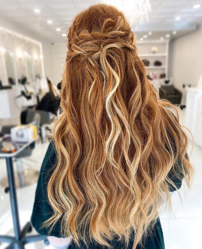 Long balayage hairstyle with loose waves and a soft braided crown detail.