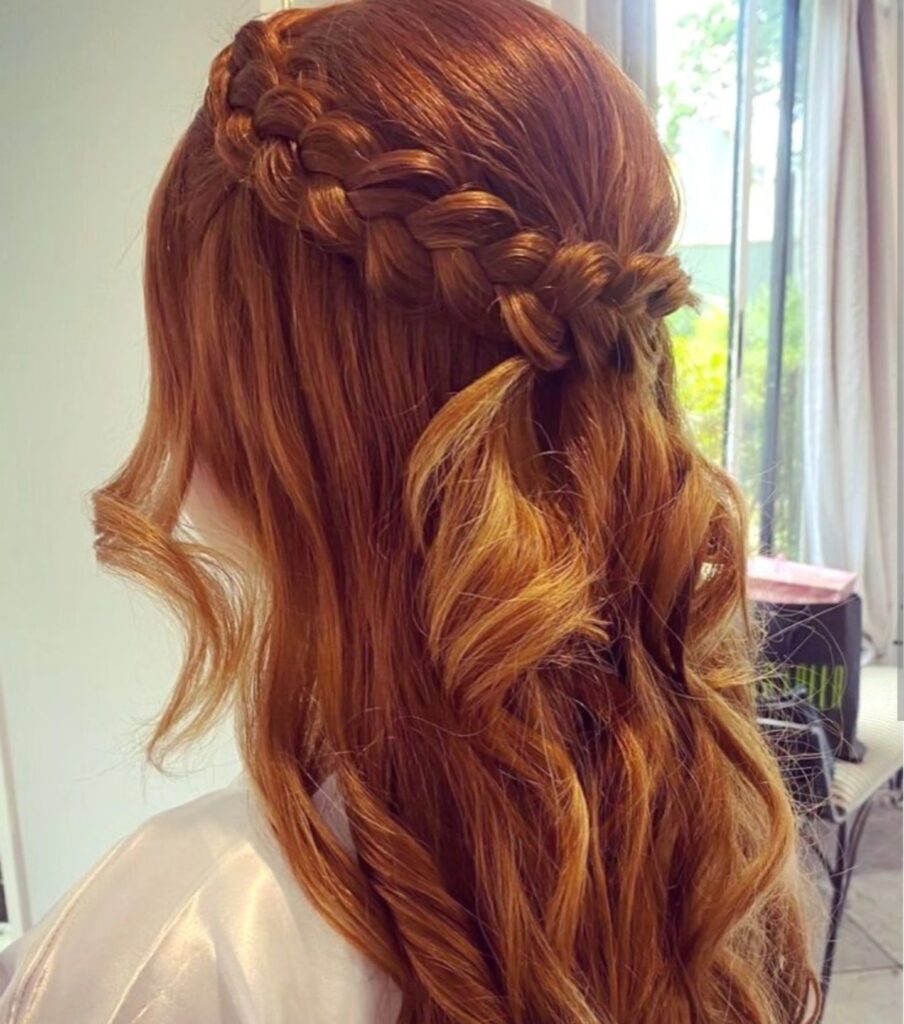 Copper red hairstyle with a thick crown braid and long curled hair.