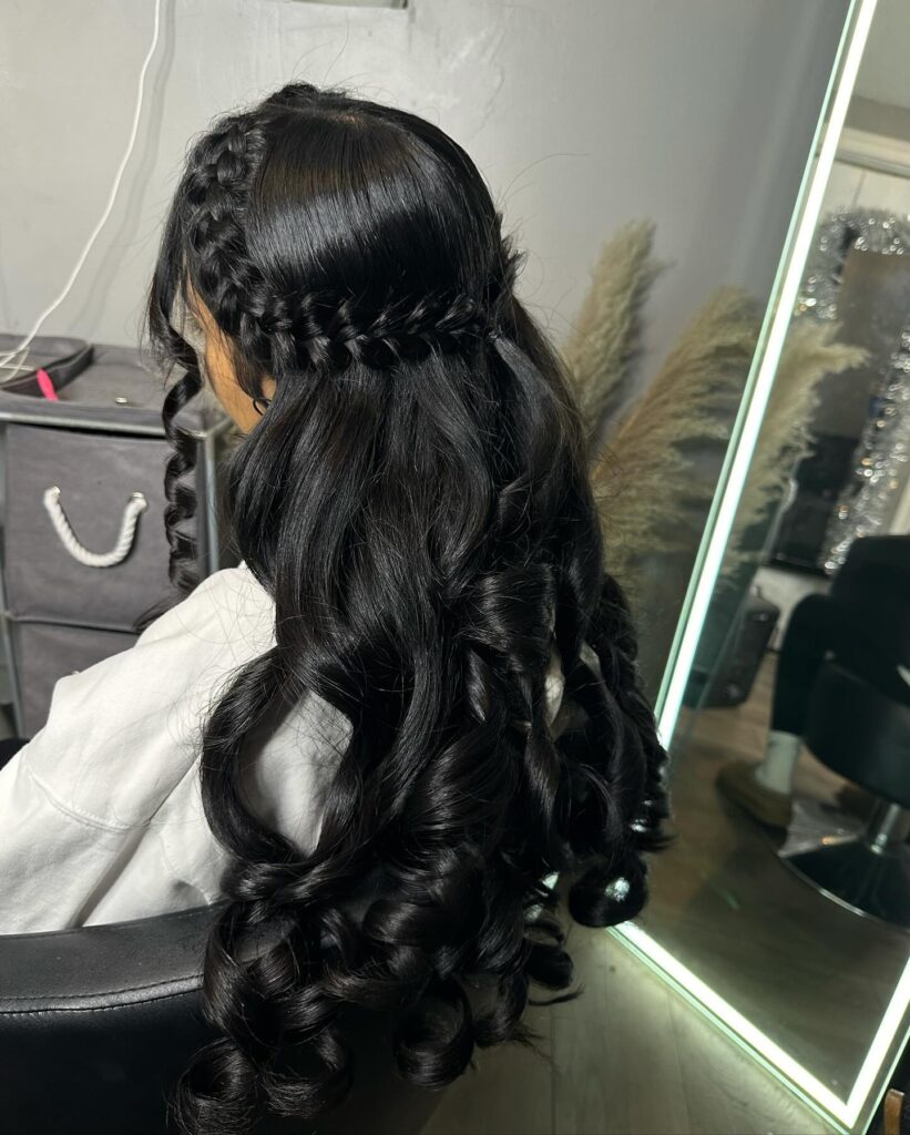 Long black curled hairstyle with a sleek braided crown across the top.