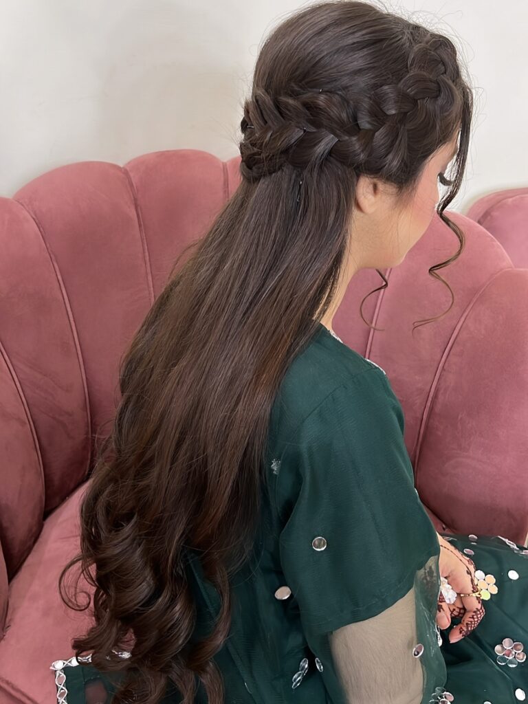 Long dark brown hairstyle with a sleek braided crown and curled ends.