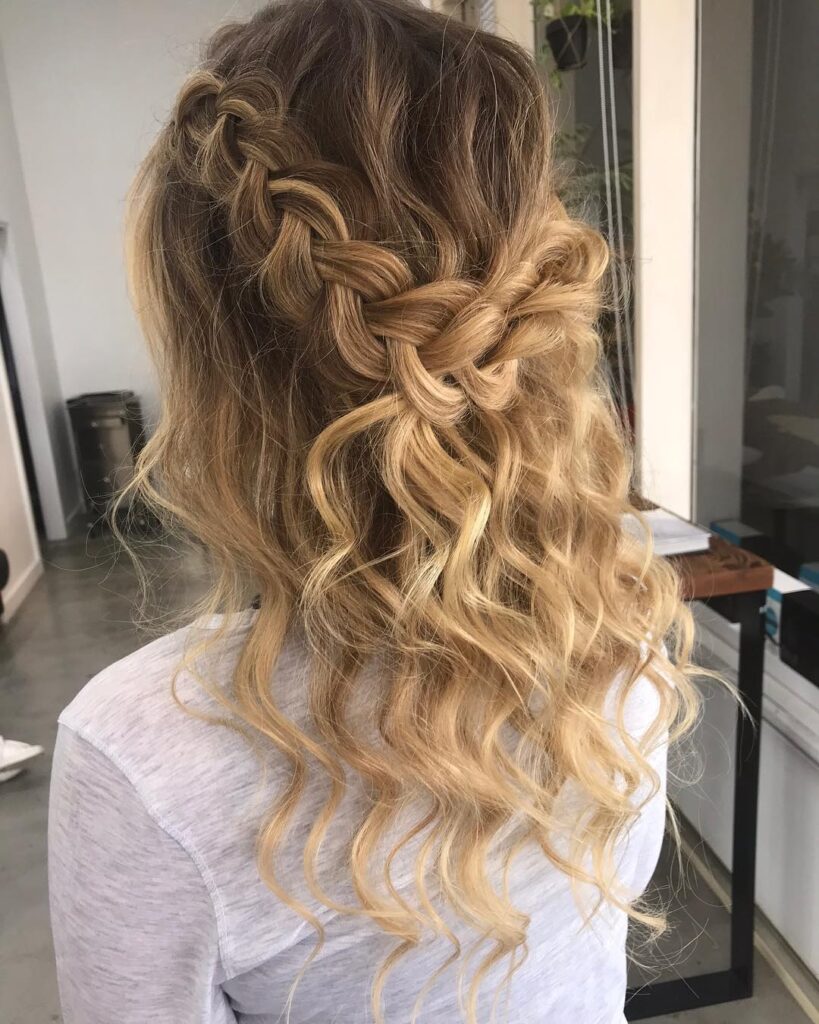 Loose braided crown hairstyle with chunky braids and long blonde wavy hair.