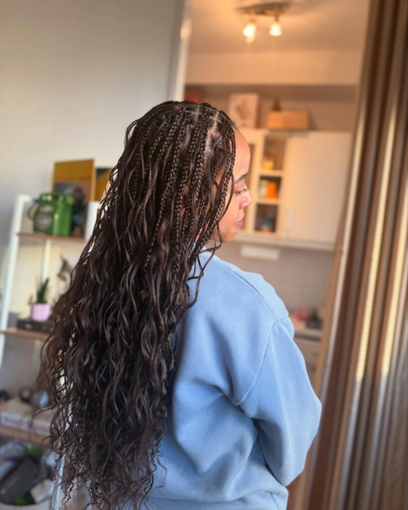 Thin micro braids with a center part flowing into long loose wavy ends.