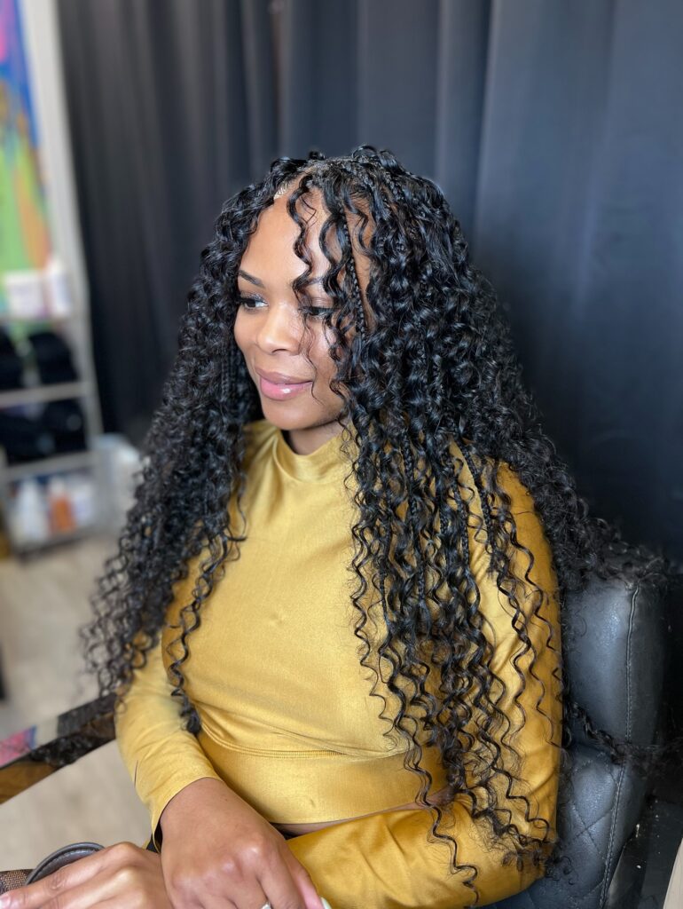 Black island braids with tight curly ringlets and braided roots.