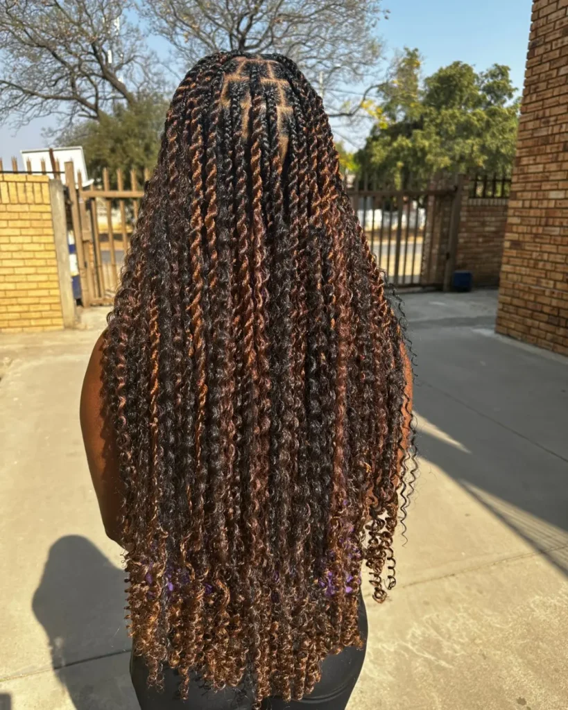 Long island braids with curly ends and soft brown highlights throughout.