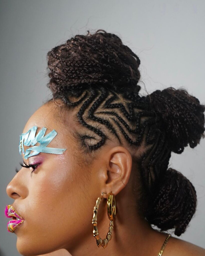 Braided mohawk with swirl cornrows styled into three rounded buns.