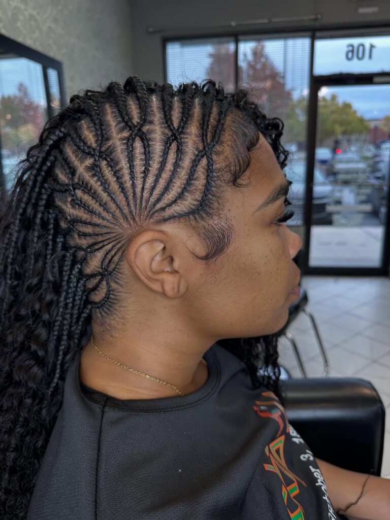 Braided mohawk with fan pattern cornrows and long braided lengths.