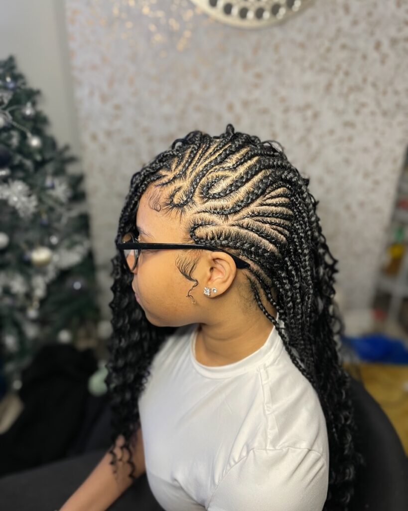 Braided mohawk with swirl cornrows and long braids finished with soft curls.