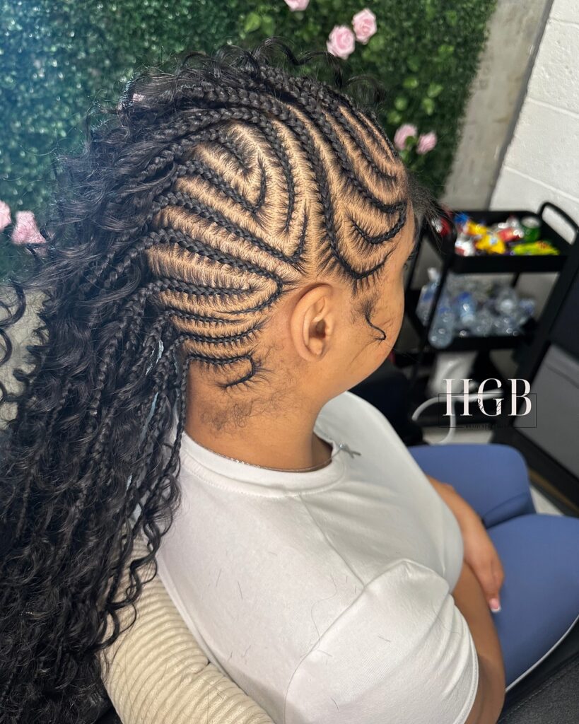 Curly braided mohawk with detailed cornrows and full voluminous curls.