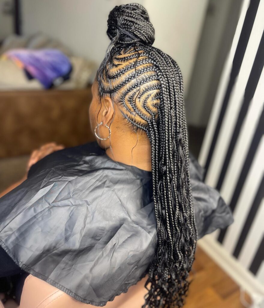 Braided mohawk with swirl cornrows and long braids styled into a high bun.