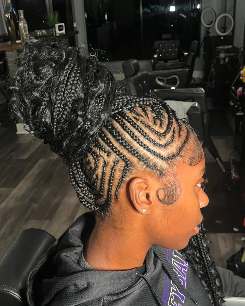 Braided mohawk with swirl cornrows and a curly top bun.