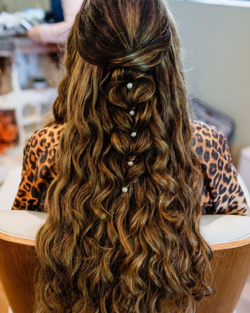 Extra long brunette hair styled in loose waves with a half up bubble braid and pearl accents.