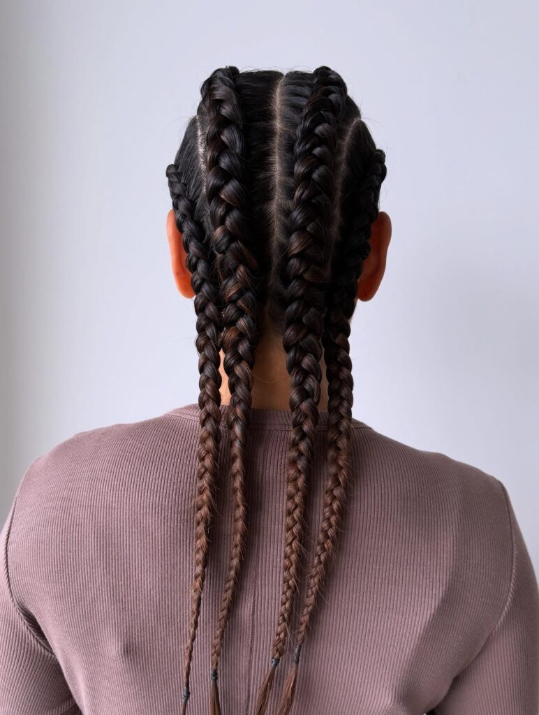 Multiple thick cornrows braided straight back in a clean and structured pattern.