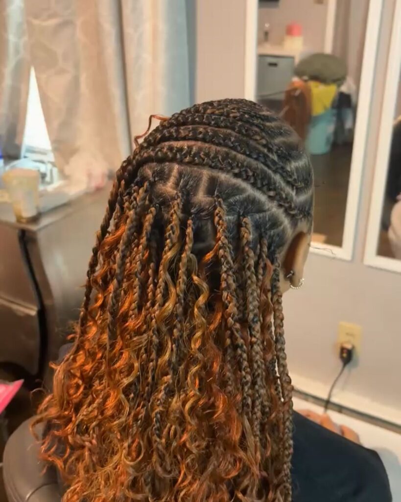 Half cornrow braids transitioning into long curly ombre ends.