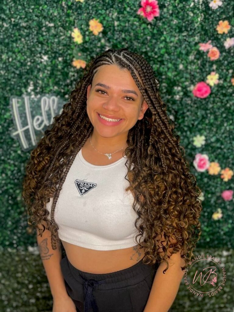 Small top braids transitioning into long voluminous curly hair for a soft playful finish.