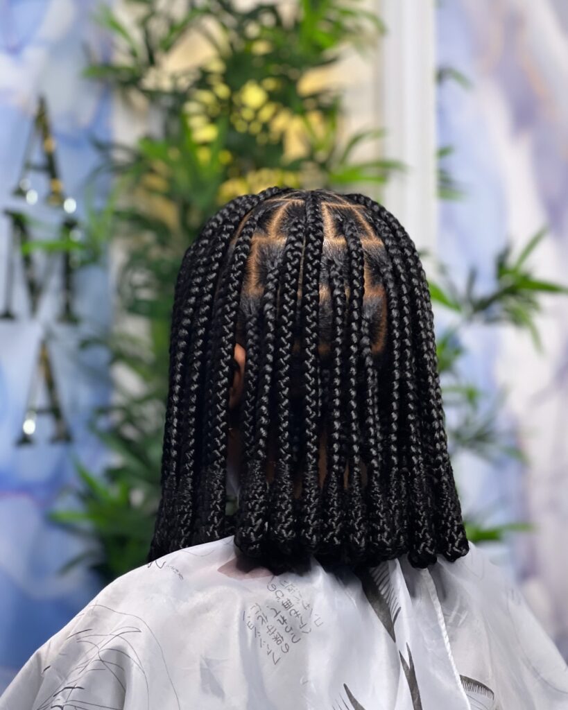 Short box braids styled into a neat bob with blunt ends and clean parts.