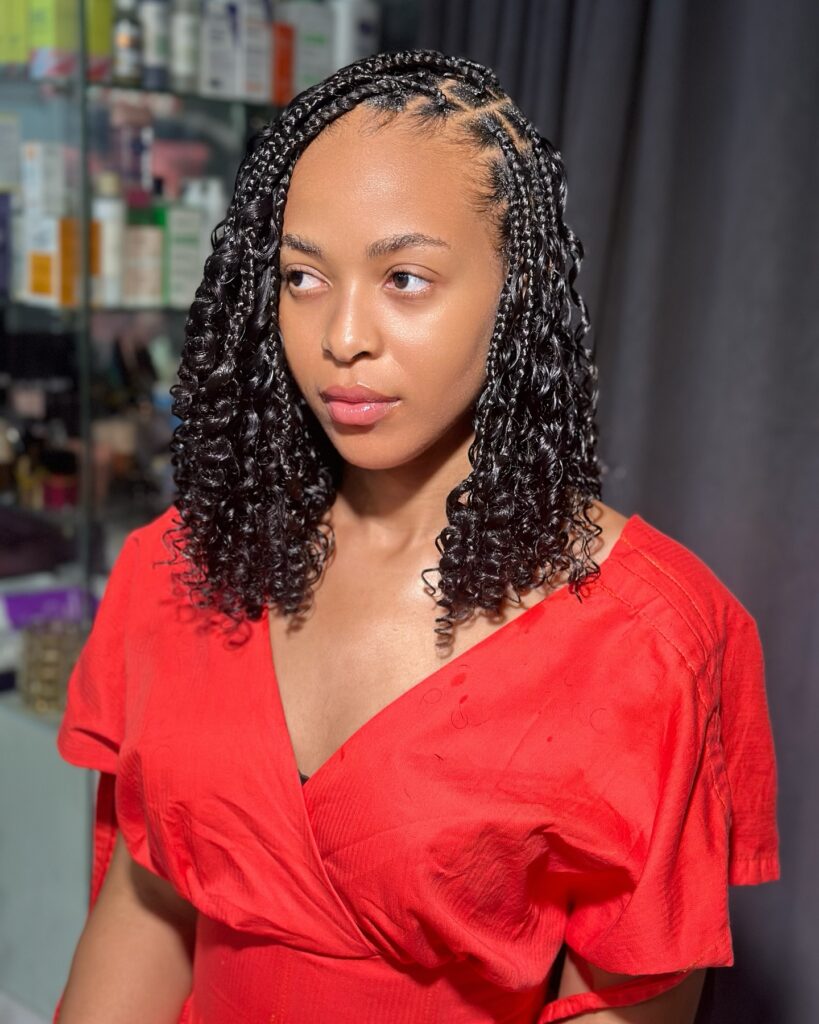 Shoulder length knotless braids with curly ends and a soft, defined finish.