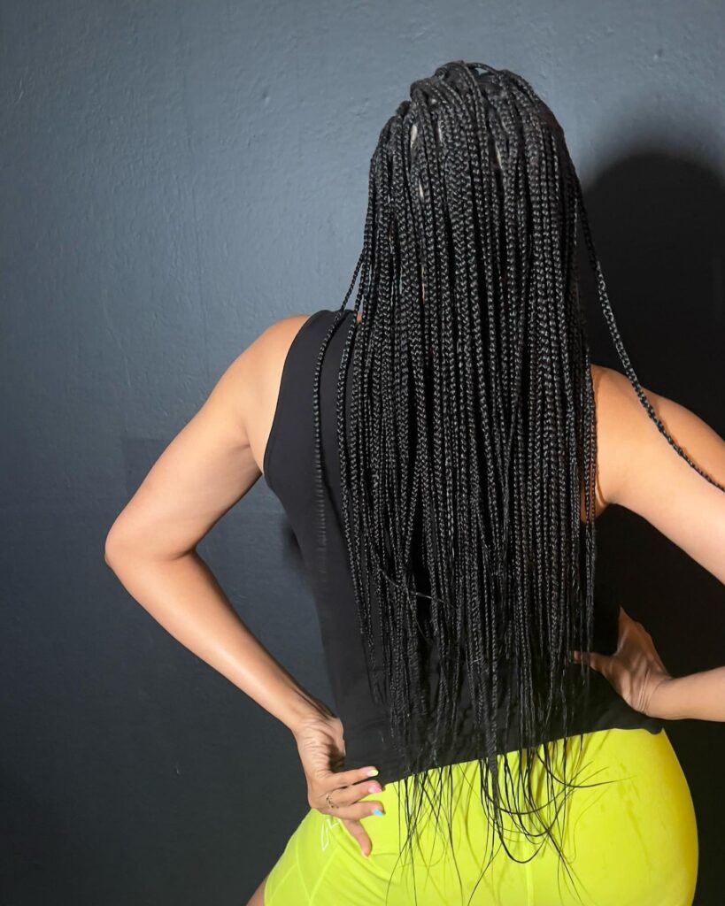 Long black micro braids with thin sleek sections and waist length styling.