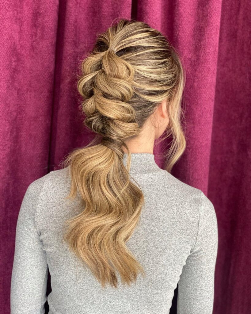 Blonde ponytail styled with a large bubble braid down the back.
