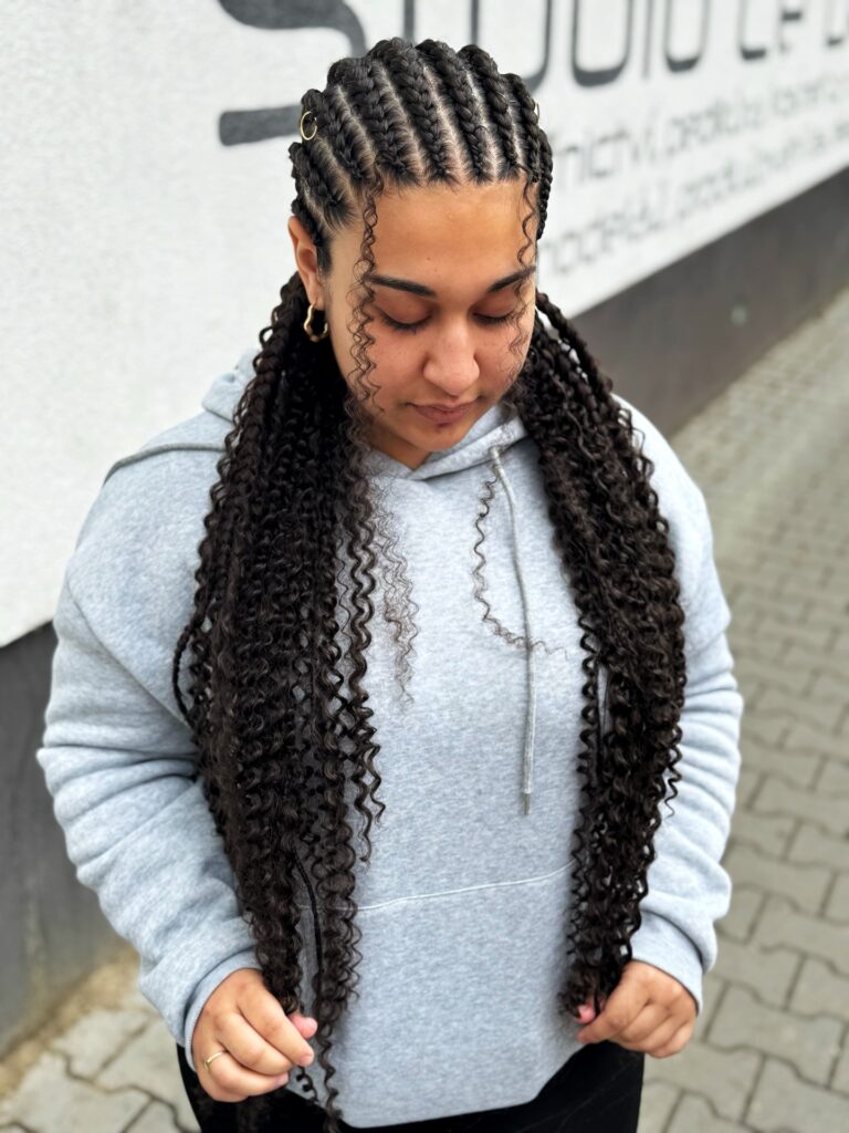 Dark curly pigtails styled with neat cornrow braids along the scalp.