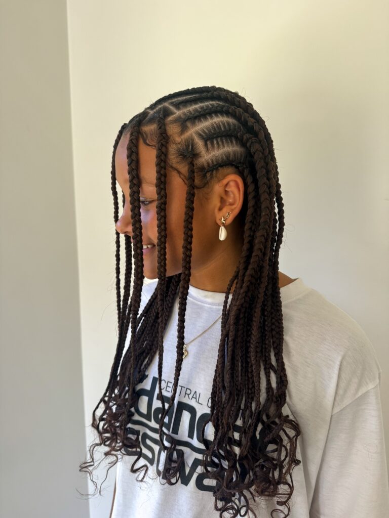 Long knotless braids with loose curly ends and a natural finish.