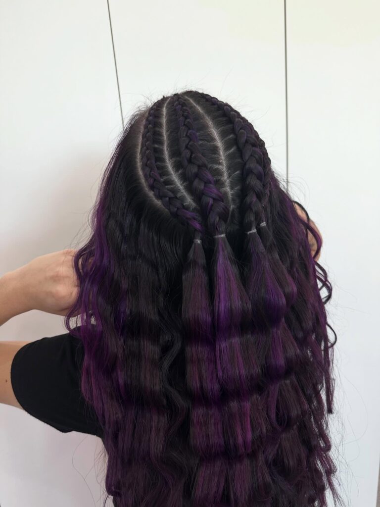 Half up cornrow braids with long crimped black and purple waves.
