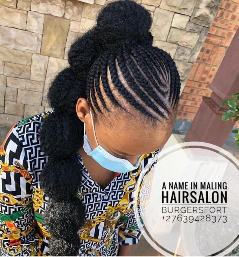 A braided ponytail with curved side braids and a thick natural textured ponytail.