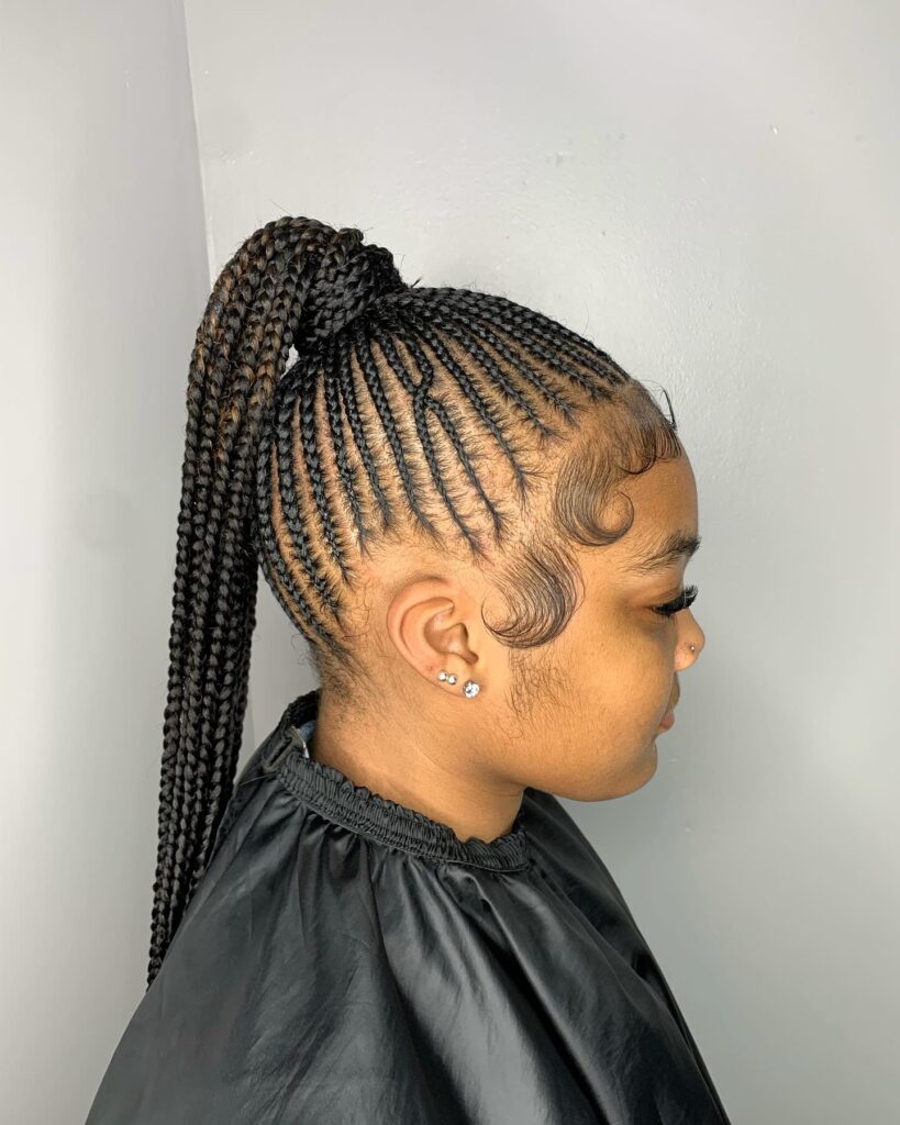 A sleek high ponytail with long feed in braids and styled baby hairs.
