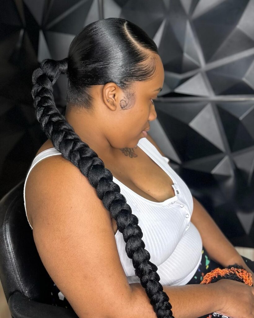 A sleek middle part ponytail styled into one long thick jumbo braid.
