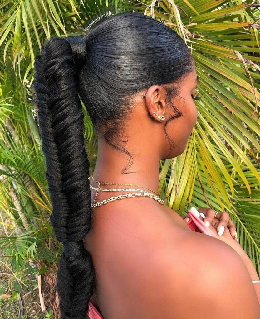 A sleek ponytail styled into a long twisted rope braid with curled tendrils.
