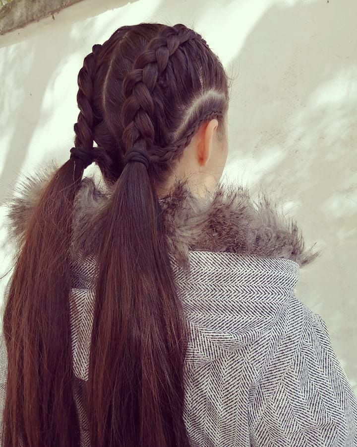 Back view of dark brown double braids flowing into long low ponytails.