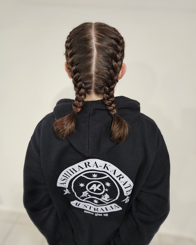 Back view of short dark brown double braids styled with a clean center part.