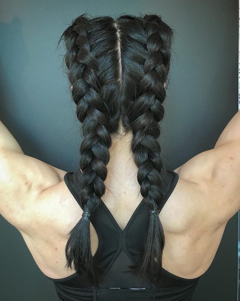 Back view of thick black boxer braids styled neatly for a sporty workout look.