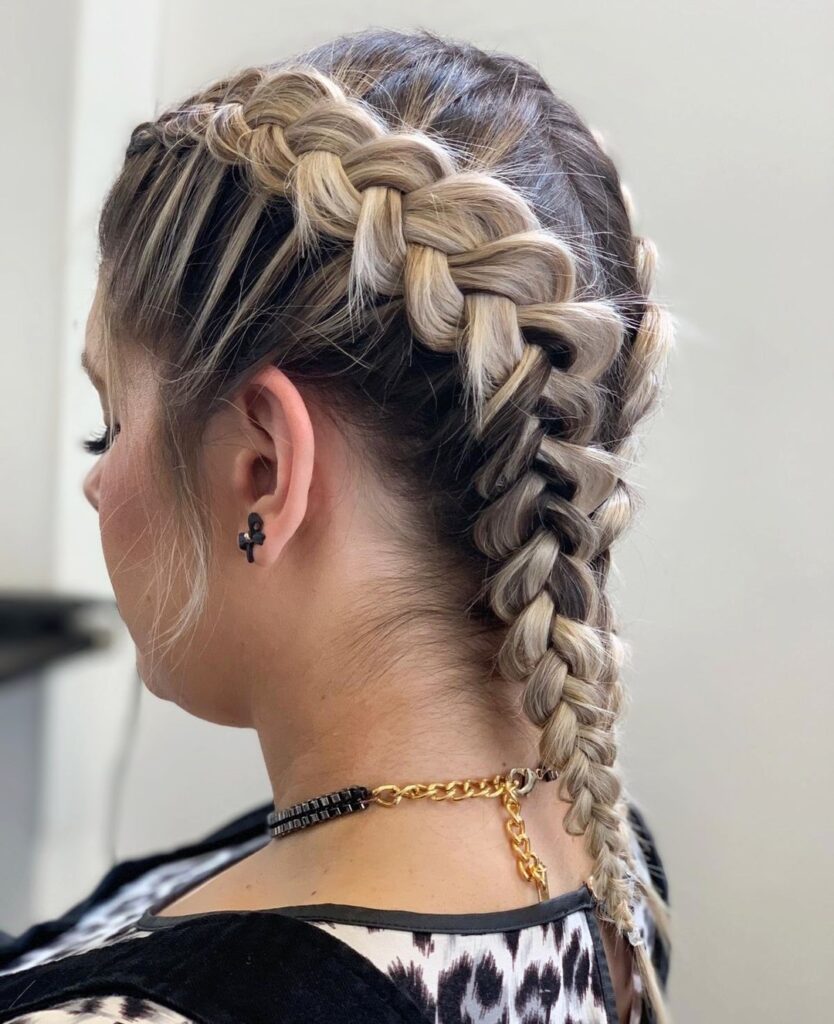 Close up view of chunky blonde Dutch braids styled tightly against the scalp for a sporty hairstyle.