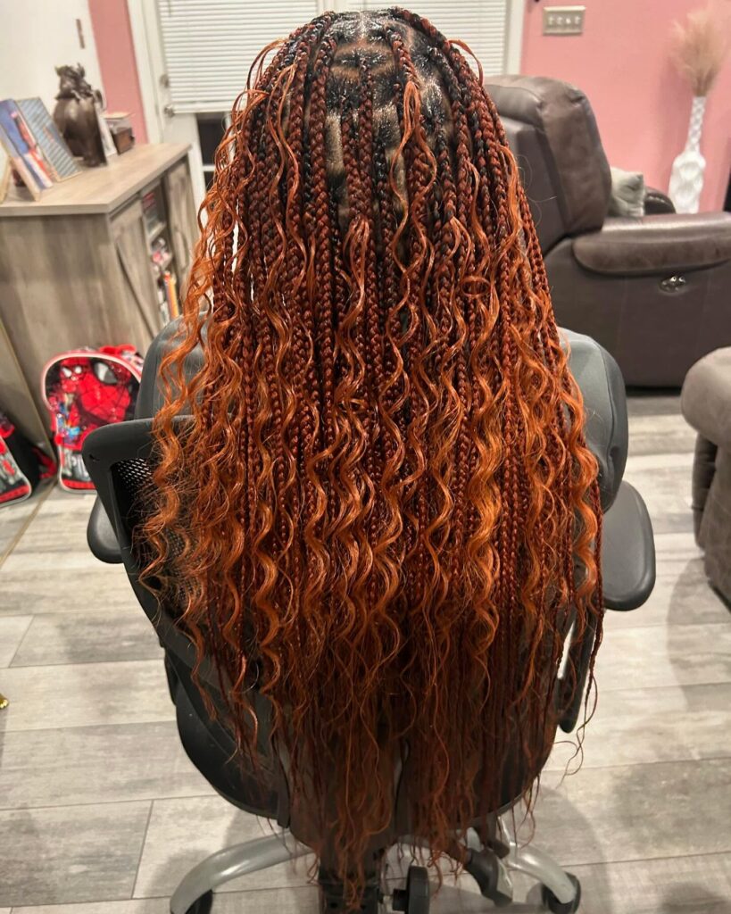 Long copper boho braids with loose wavy strands and textured ends.