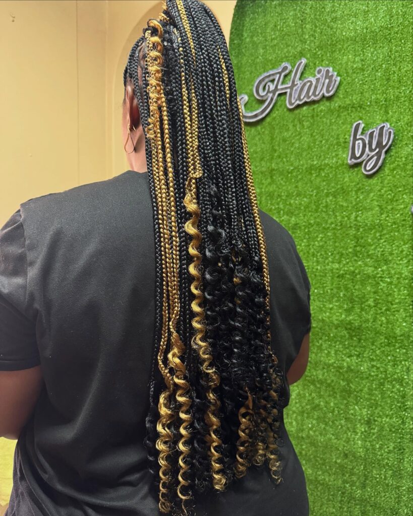 Extra long black boho braids with blonde highlighted curly strands.
