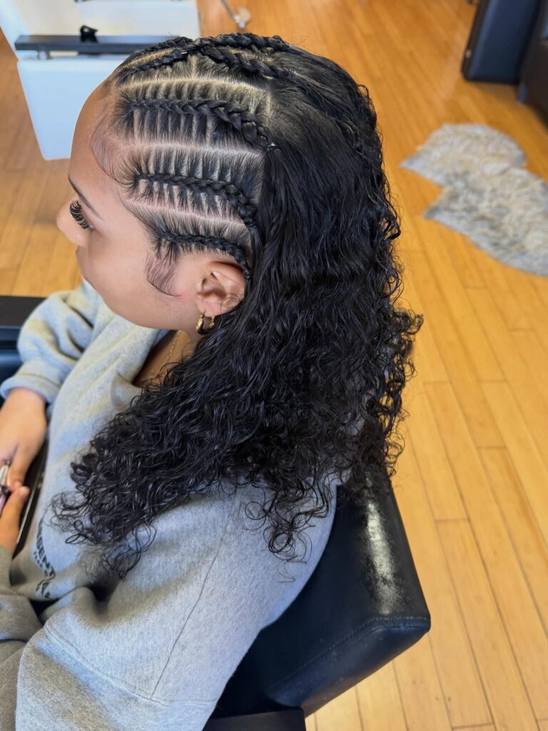 Feed in braids with detailed scalp braids and loose curly hair in the back.