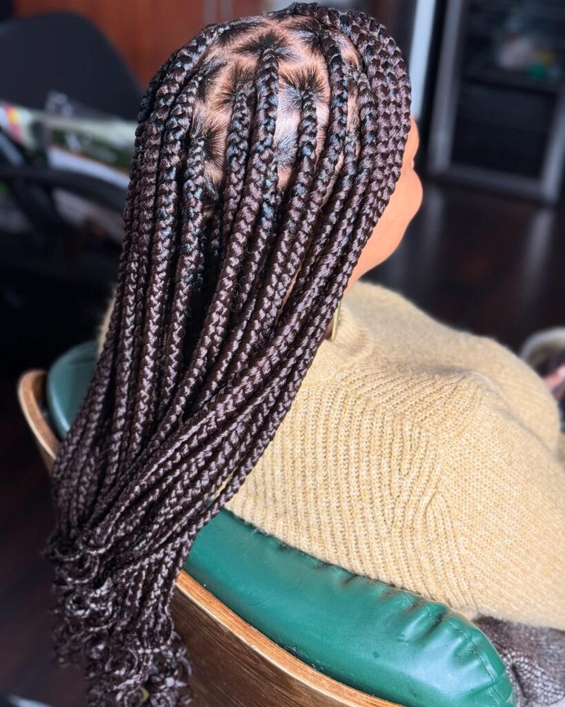 Long medium sized knotless braids with neat scalp parting and a sleek finish.